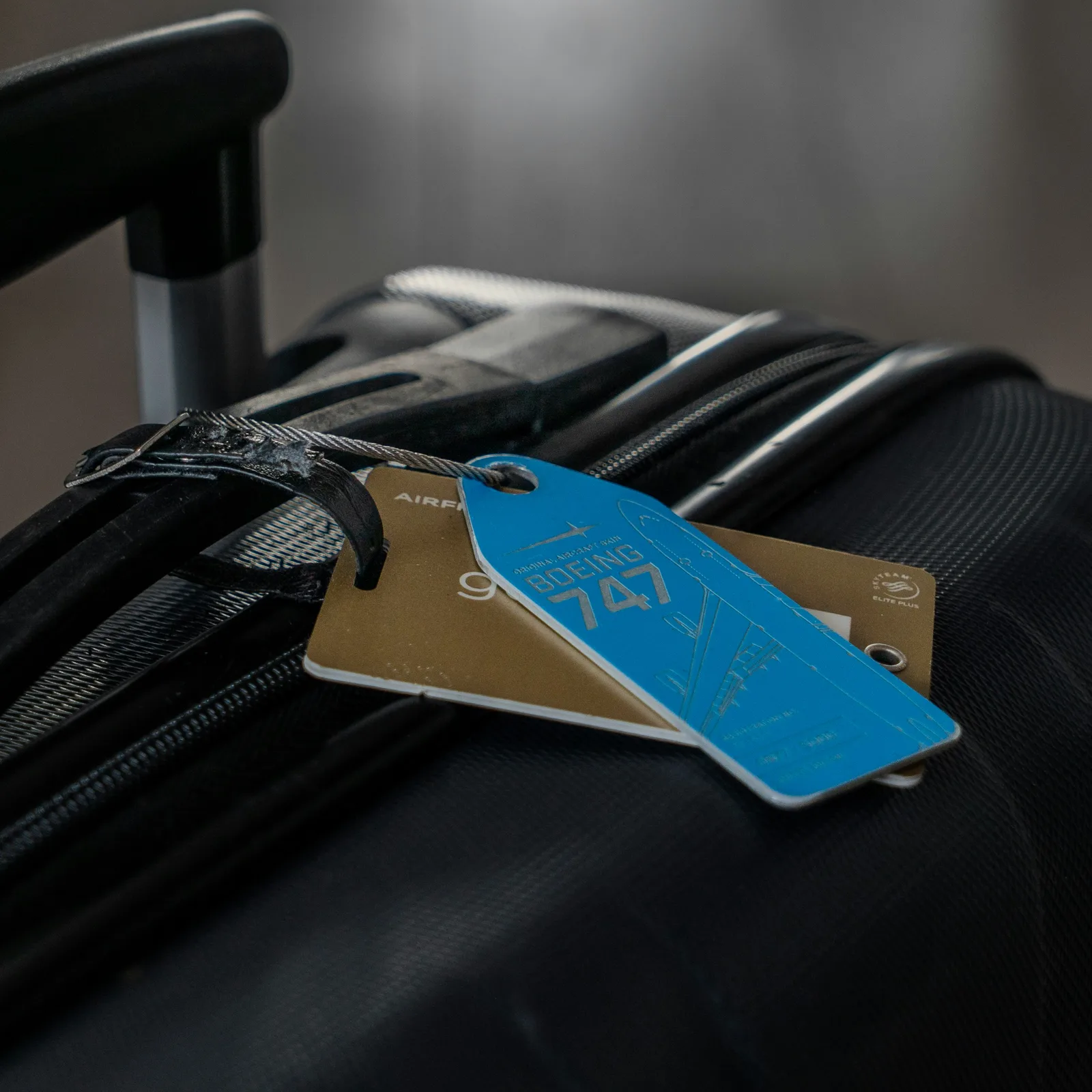 A suitcase with a blue luggage tag attached to the handle