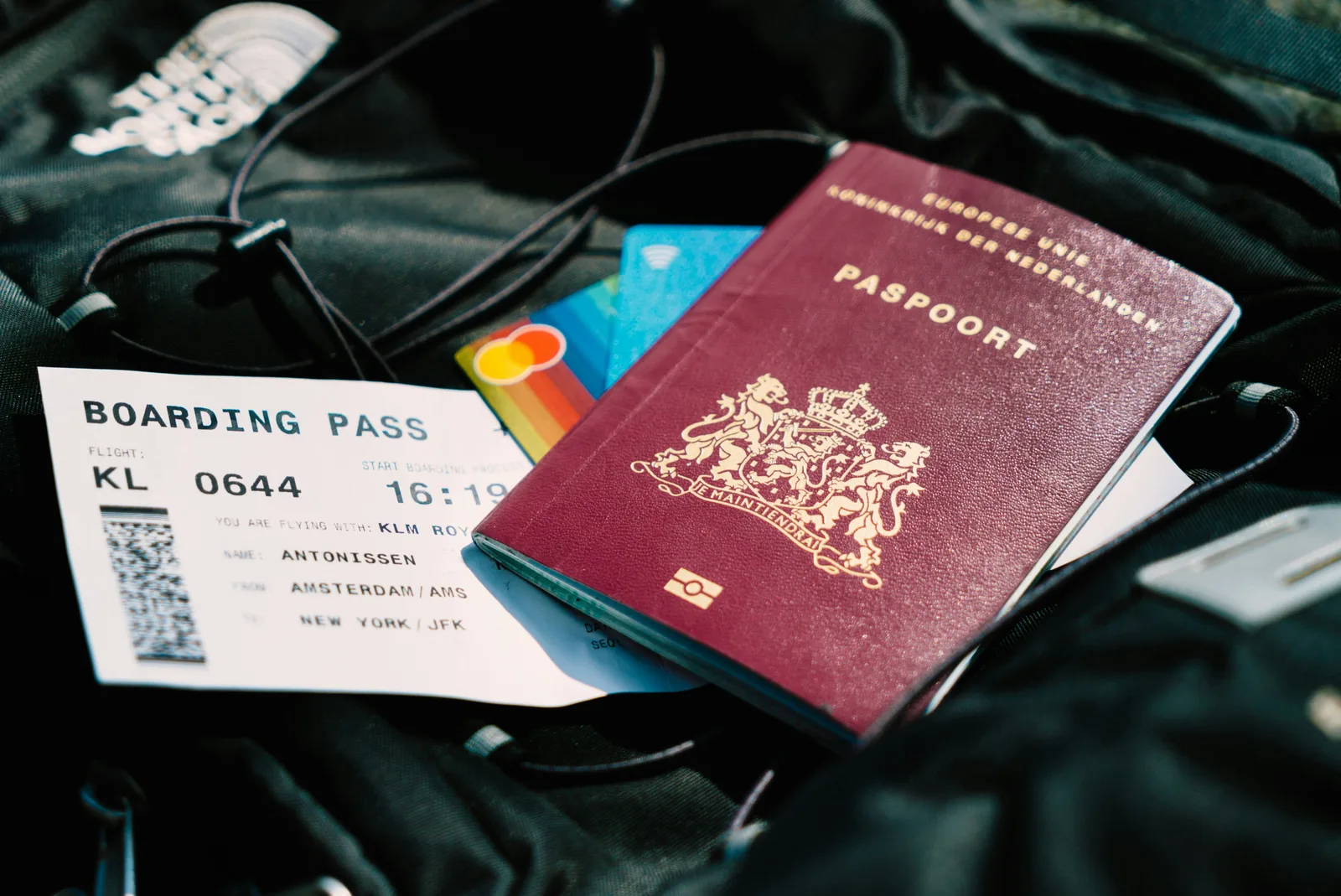A passport and a boarding pass resting on top of a travel bag