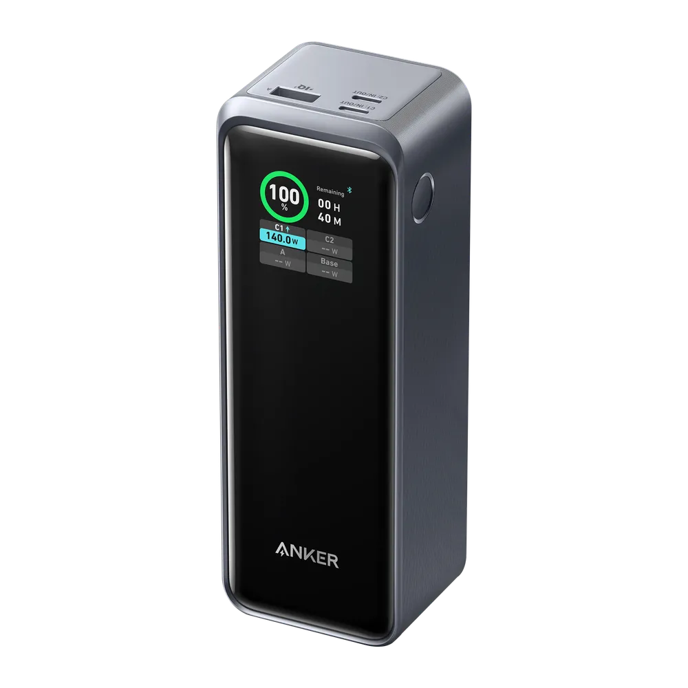 The Anker Prime power bank, a tall dark grey brick with a bright display reading 100 percent and 140.0W, and three ports across the top
