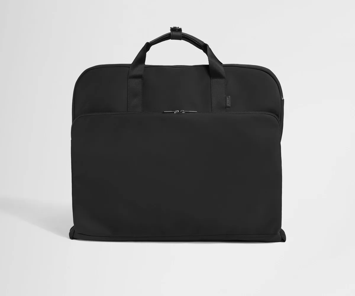 The Away Garment Bag in jet black, a bi-fold travel garment bag with leather trim and a trolley sleeve