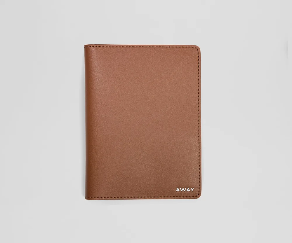 A slim leather Away passport holder in a neutral tone