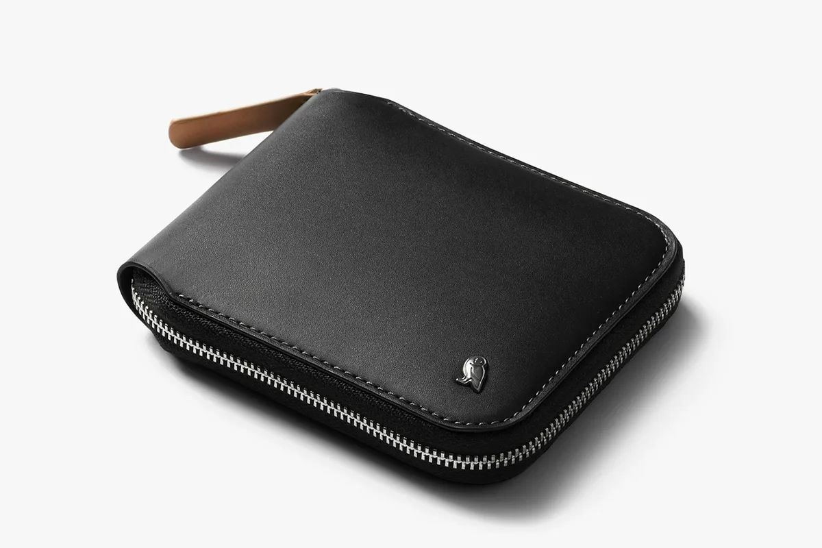 Black leather Bellroy Zip Wallet with a tan zipper pull and the Bellroy bird logo