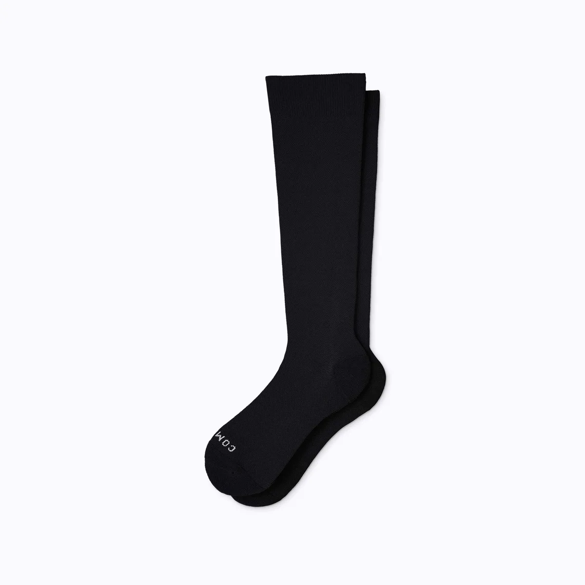 A pair of black Comrad knee-high compression socks laid flat