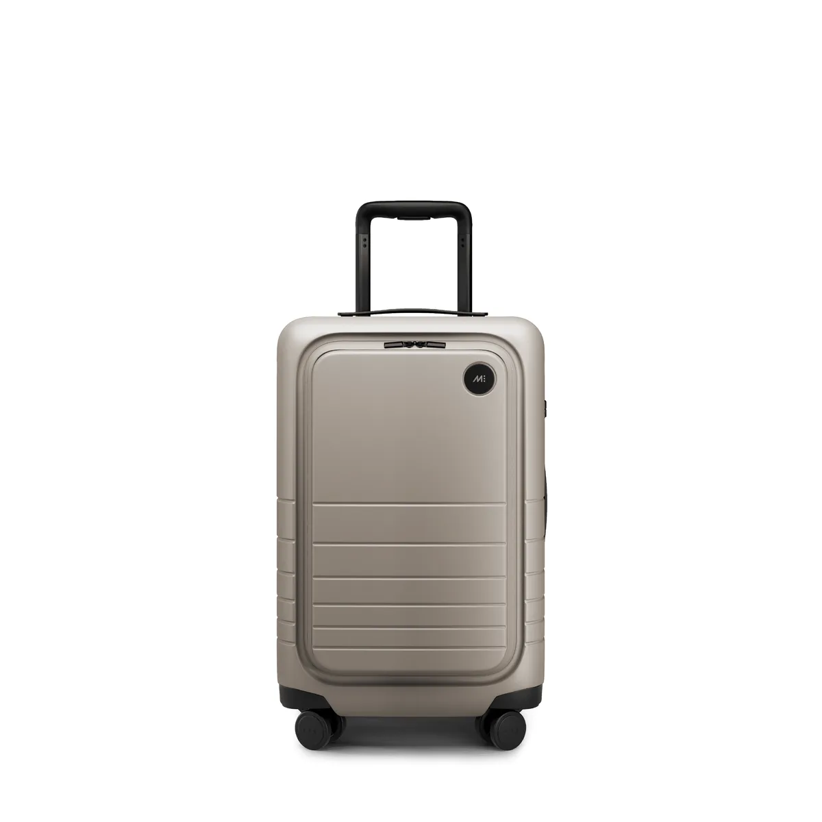 The Monos Carry-On Pro in a desert taupe colorway, a hardside spinner with a front laptop pocket