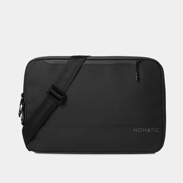 The Nomatic Tech Case in black, a slim padded organizer that holds a 16-inch laptop plus chargers, with a luggage pass-through strap