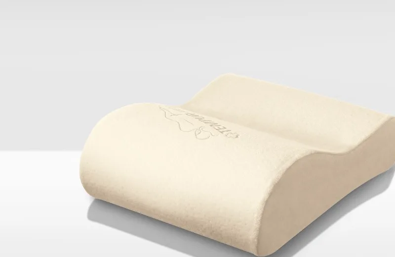 The contoured cream Tempur-Pedic NeckPillow Travel on a plain background
